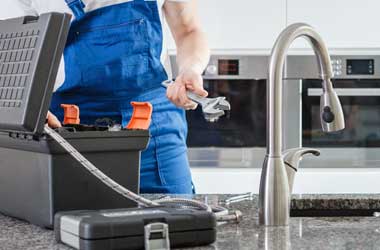 Plumber Removing Tools From His Tool Box to Fix Kitchen Sink in Houston