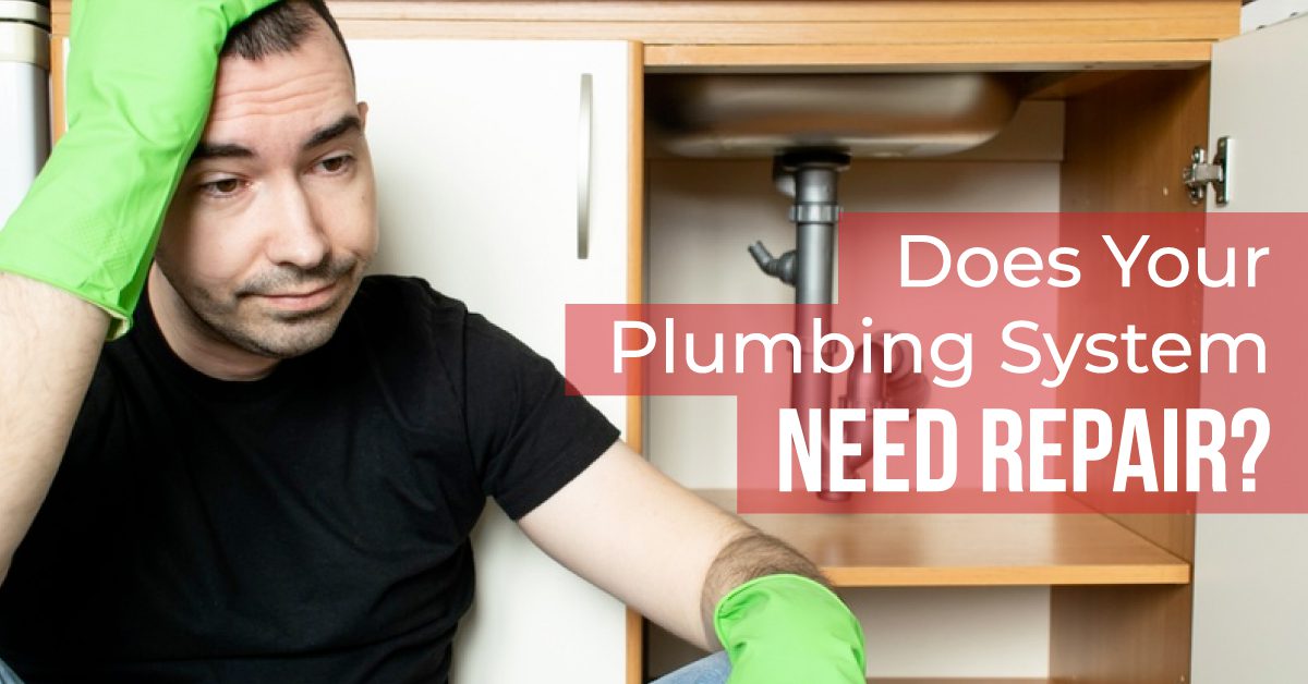 Worried Homeowner Sitting Next to an Under-Sink Pipe